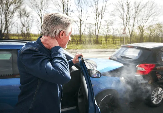 Injured man exiting his car vehicle while holding his neck after an auto accident in Georgia